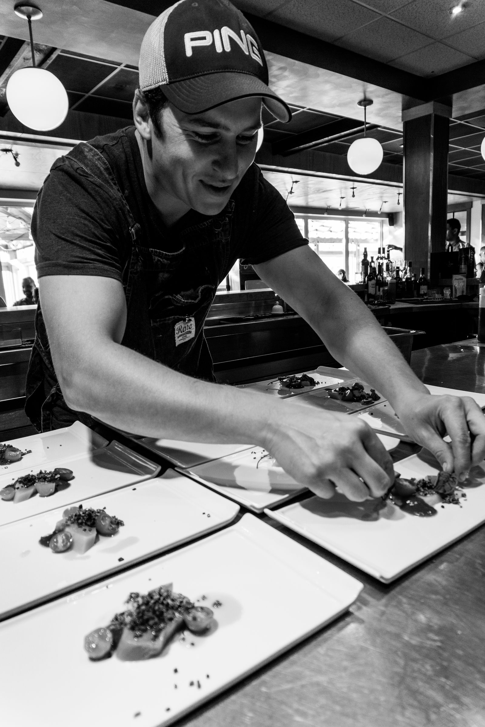 Le chef Benjamin Cormier dresse les assiettes en cuisine ouverte